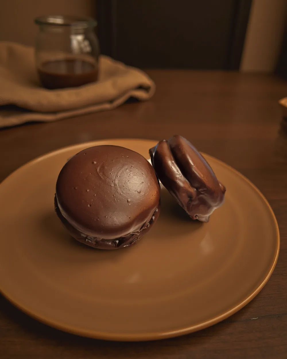 Two chocolate alfajores on a plate